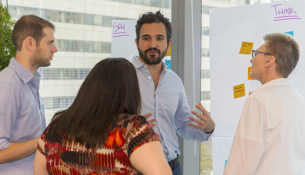 People at a white board going through a facilitated activity